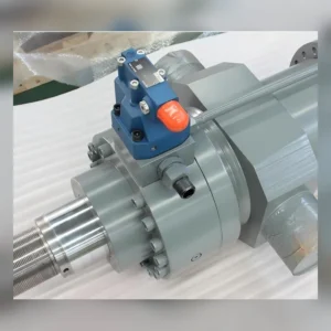 Close-up of machine valve with blue housing and orange button
