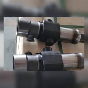 Two black mounting parts attached to metallic cylinders on surface