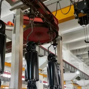 Black telescopic cylinders suspended in factory setting