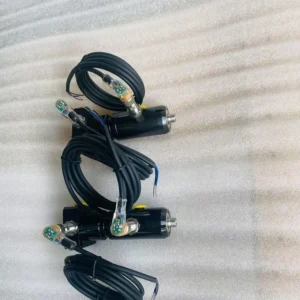 Coiled black cable with connectors on fabric surface.