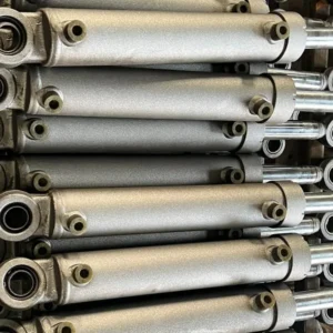 Multiple industrial hydraulic cylinders stored in a row
