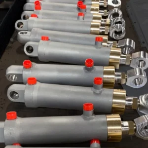 Telescopic cylinders arrayed with red caps on industrial surface