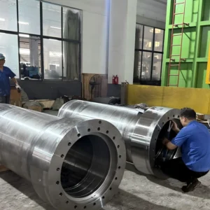 Two large welded cylinders in factory with workers