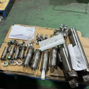 Various mechanical components including cylinders and rods on workbench